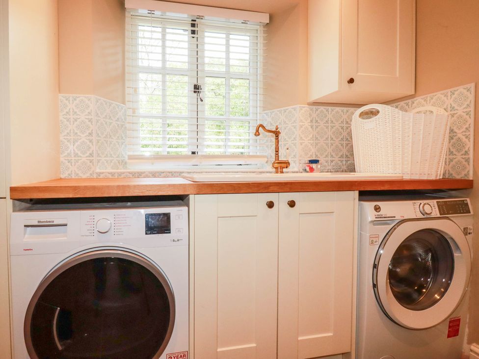 A laundry room with washing machine, dryer, and countertop at The Homestead in 