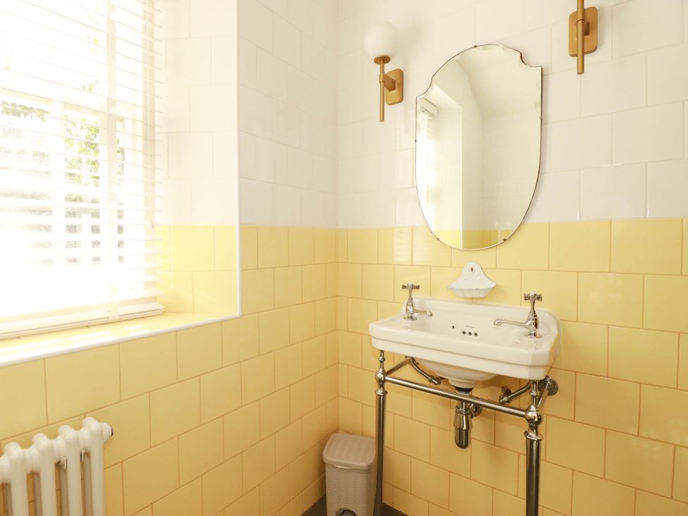 A bathroom with a sink and mirror at The Homestead in 