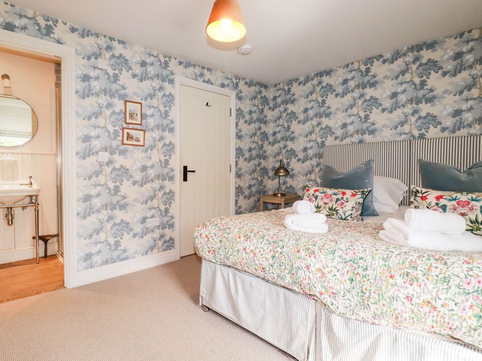 A bedroom with floral bedding and a washbasin at The Homestead in 