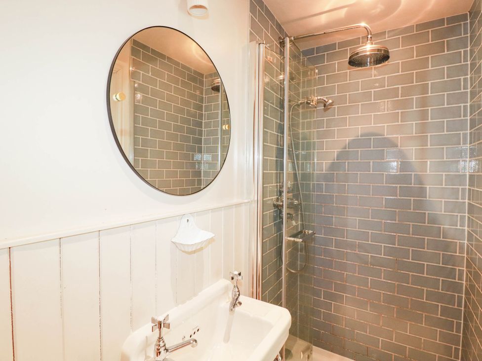 A bathroom with a mirror and shower at The Homestead 