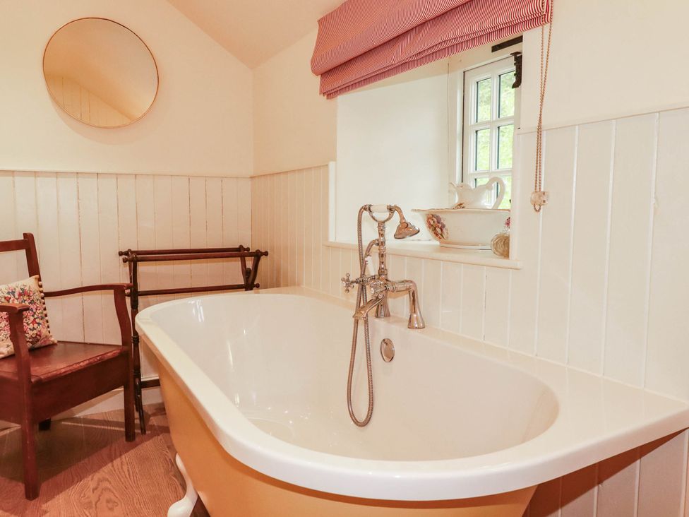 A bathroom with a bathtub and a chair at The Homestead