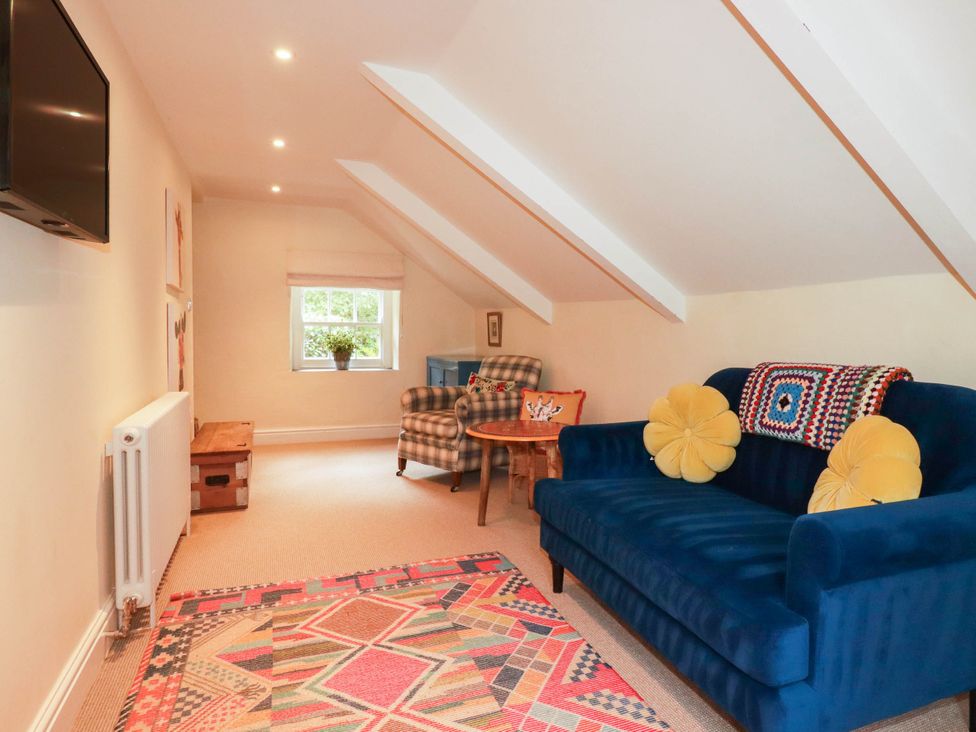 A sitting room with a blue sofa and television at The Homestead 