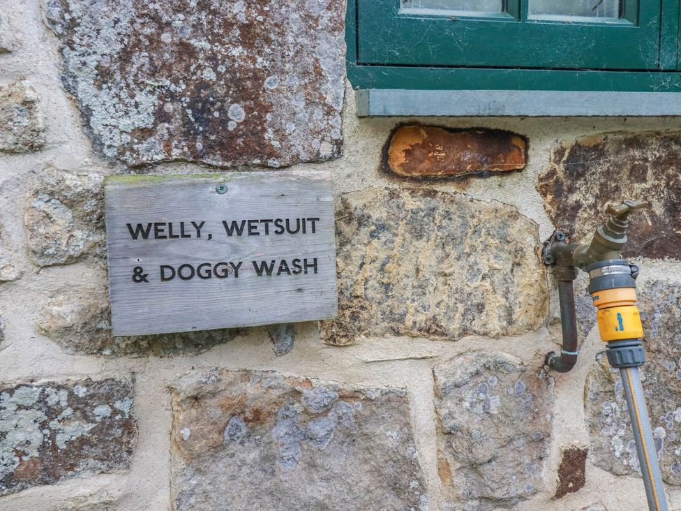 A stone wall with a wash sign and a faucet at The Homestead in 