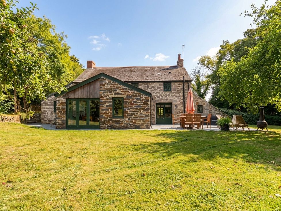A house with garden furniture and trees at The Homestead in 