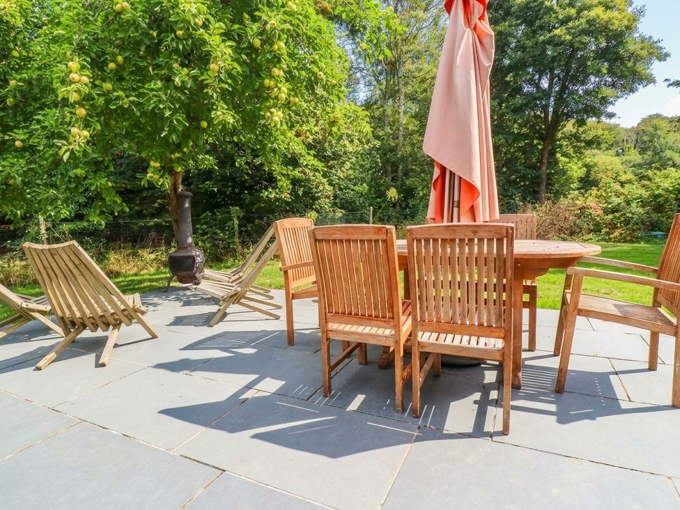 A patio with a table and chairs under an umbrella at The Homestead 