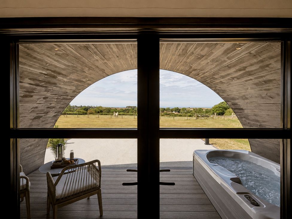 An outdoor space with a jacuzzi and seating area at The Hog Hut in Llanarth