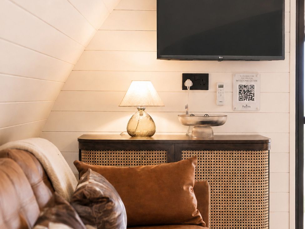 A living room with a television and lamp at The Hog Hut in Llanarth