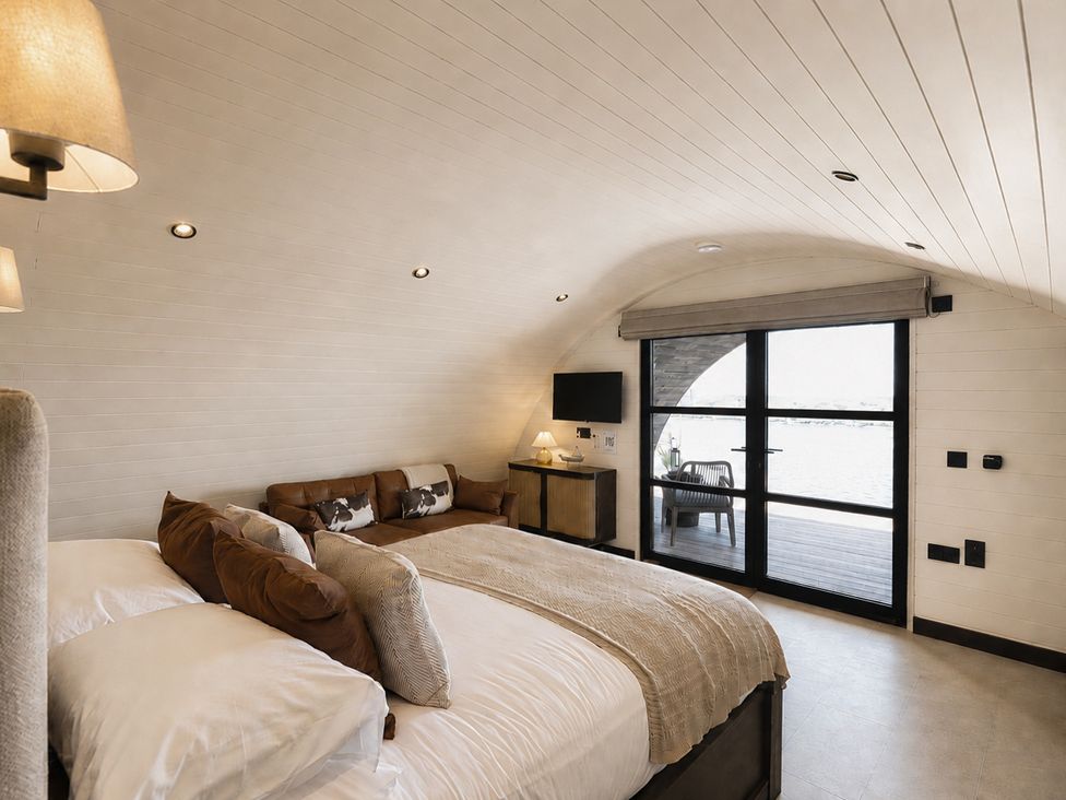 A bedroom with a bed and a sofa at The Hog Hut in Llanarth