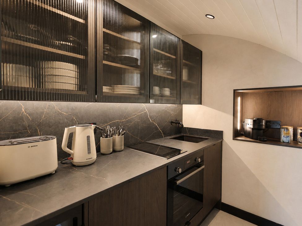 A kitchen with appliances and cabinets at The Hog Hut in Llanarth