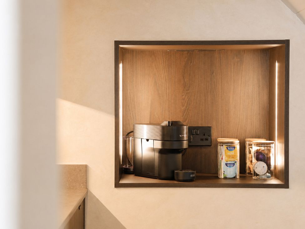 A kitchen shelf with a coffee machine and jars at The Hog Hut in Llanarth