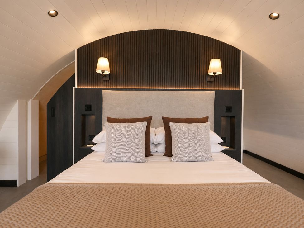 A bedroom with a bed and bedside lamps at The Hog Hut in Llanarth