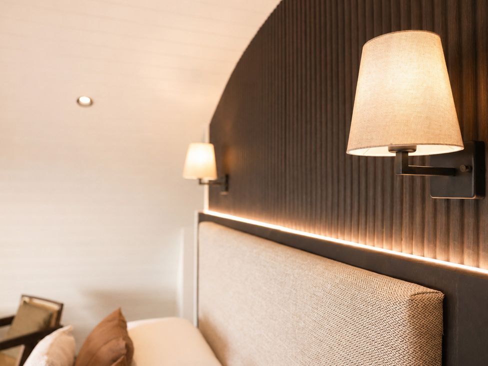 A bedroom with a lamp and headboard at The Hog Hut in Llanarth