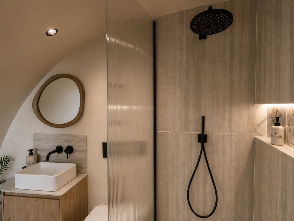 A bathroom featuring a shower, sink, and mirror at The Hog Hut in Llanarth
