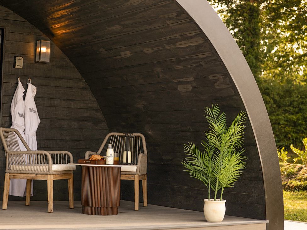 An outdoor seating area with chairs and a table at The Hog Hut in Llanarth