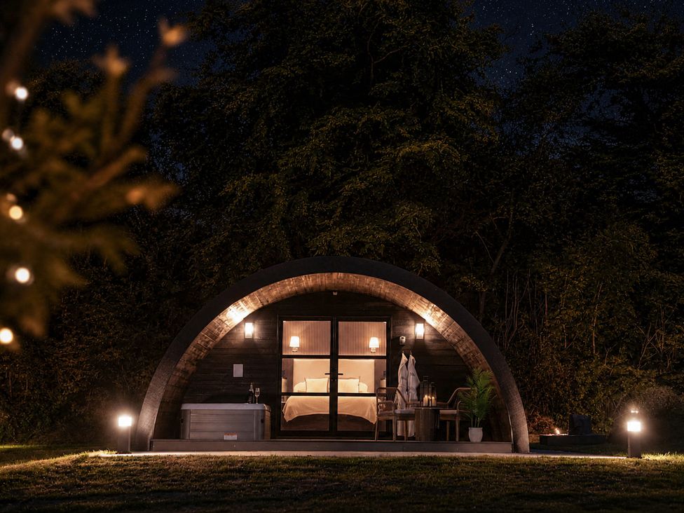 An outdoor structure with a hot tub and seating at The Hog Hut in Llanarth