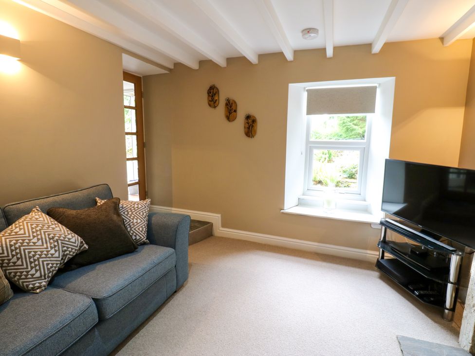A living room with a sofa and television at Woody Bank
