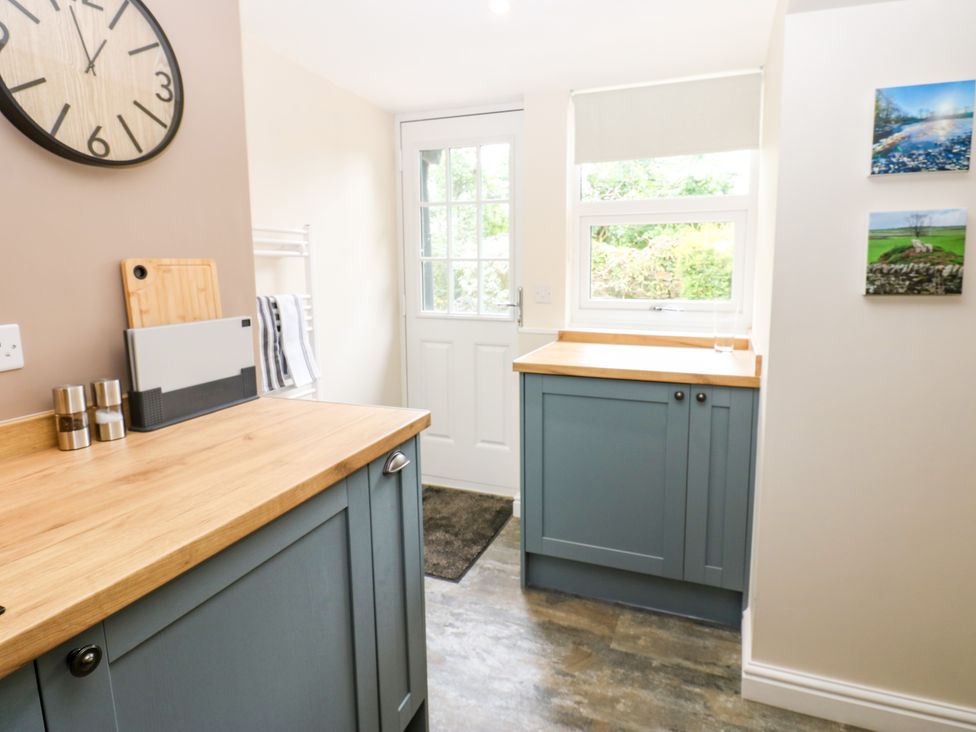 A kitchen with countertop, cabinets, and a door at Woody Bank