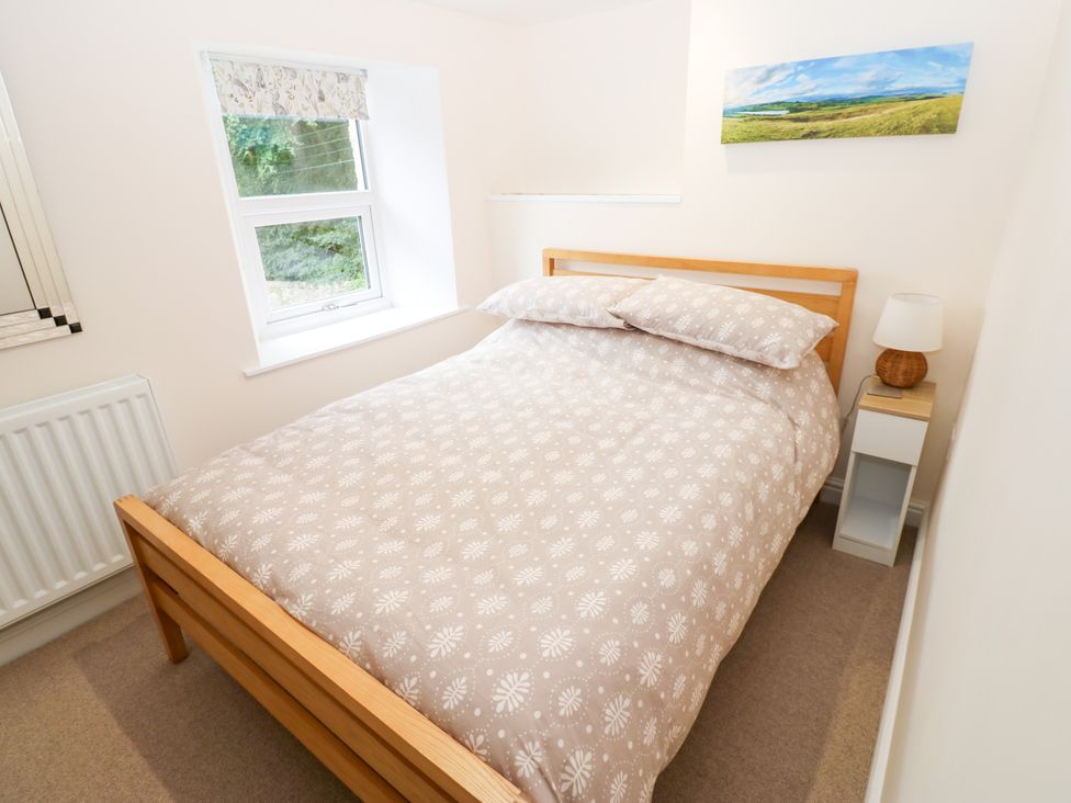 A bedroom with a bed and a bedside table at Woody Bank