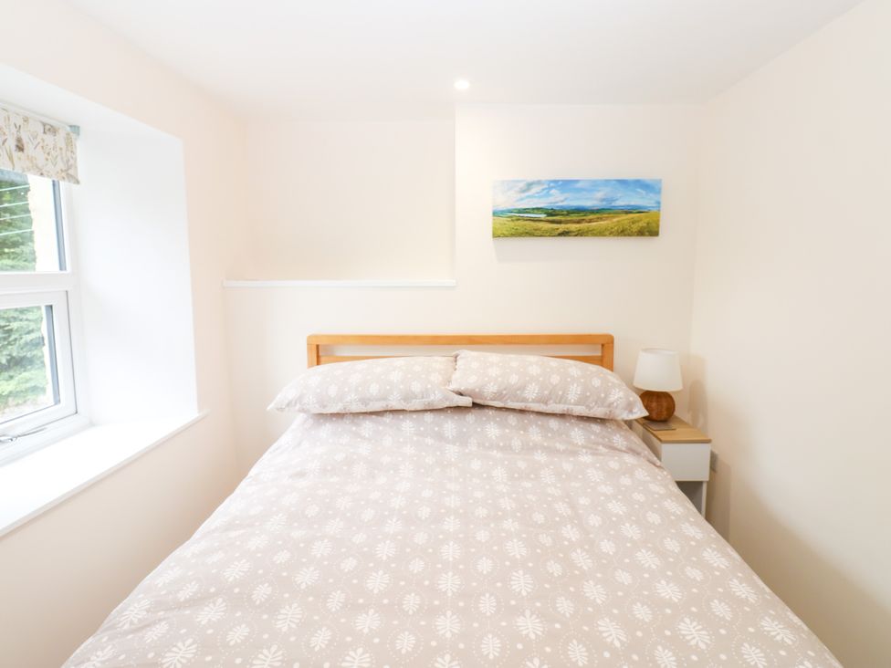 A bedroom with a bed and bedside table at Woody Bank in 
