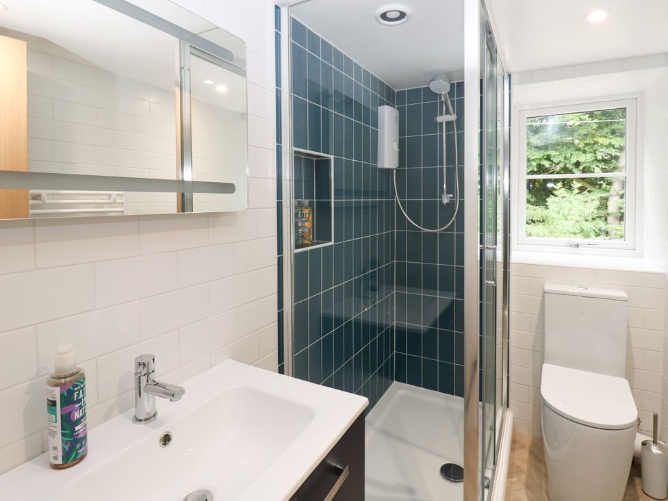 A bathroom with a shower, sink, and toilet at Woody Bank