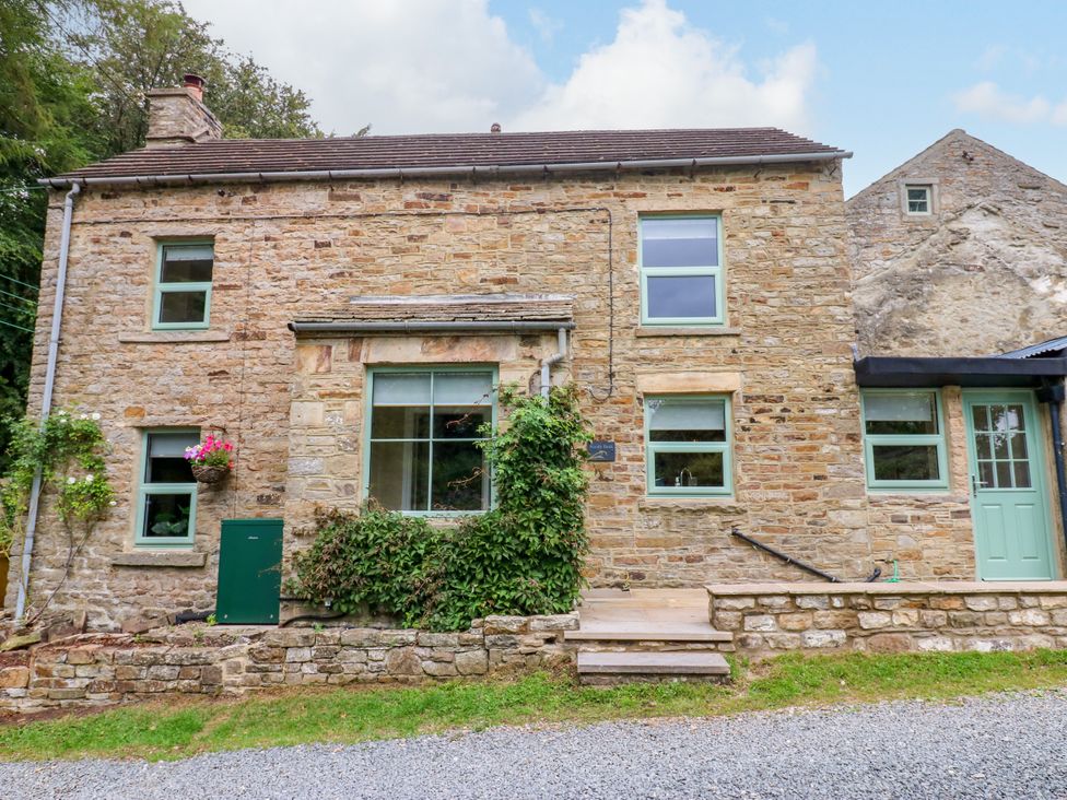 A stone house with windows and a door at Woody Bank