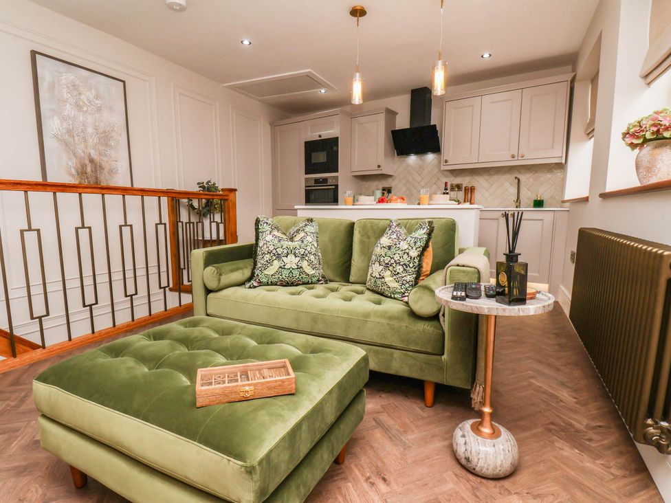 A living room with a green sofa and coffee table at 14 Brunswick Street Whitby