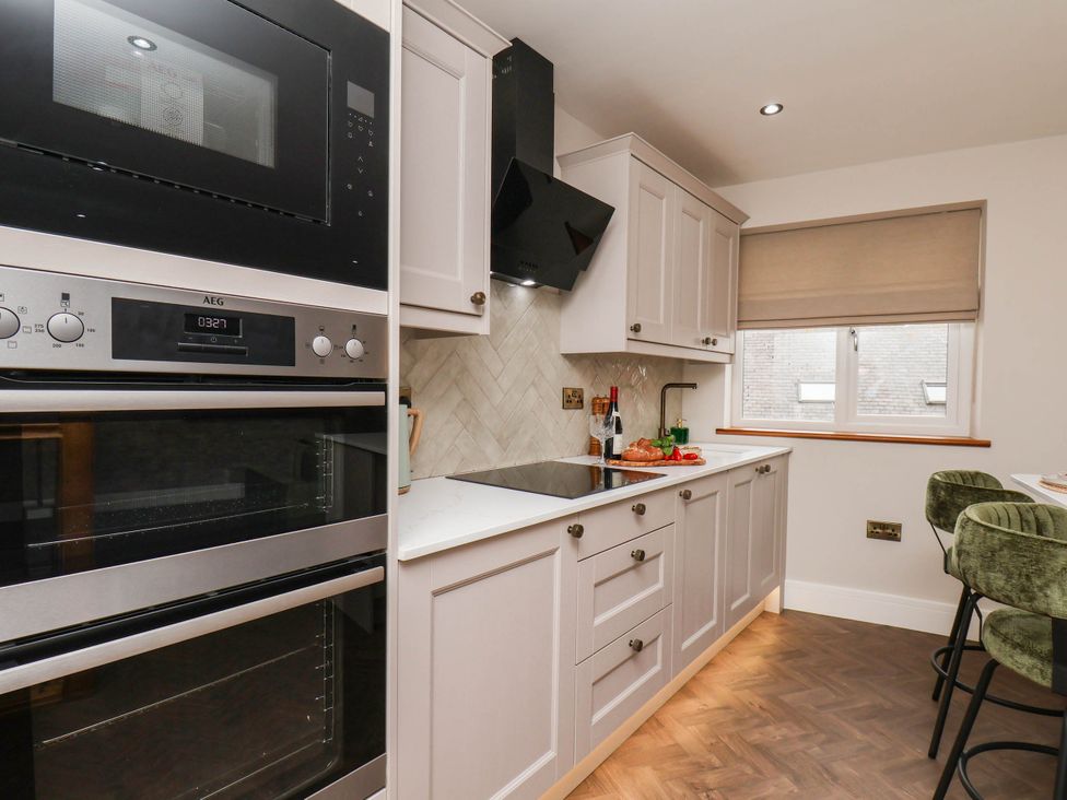 A kitchen with a microwave, oven, and stove at 14 Brunswick Street in Whitby