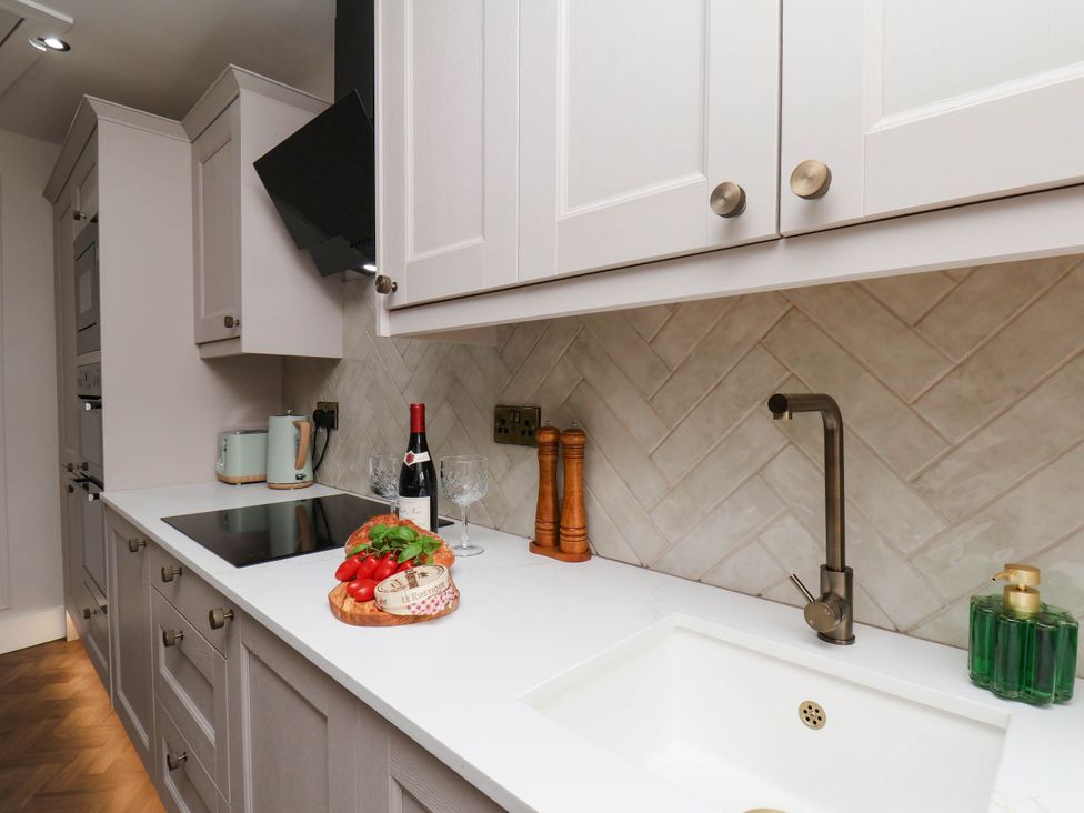 A kitchen with a sink, cooktop, and cutting board at 14 Brunswick Street Whitby