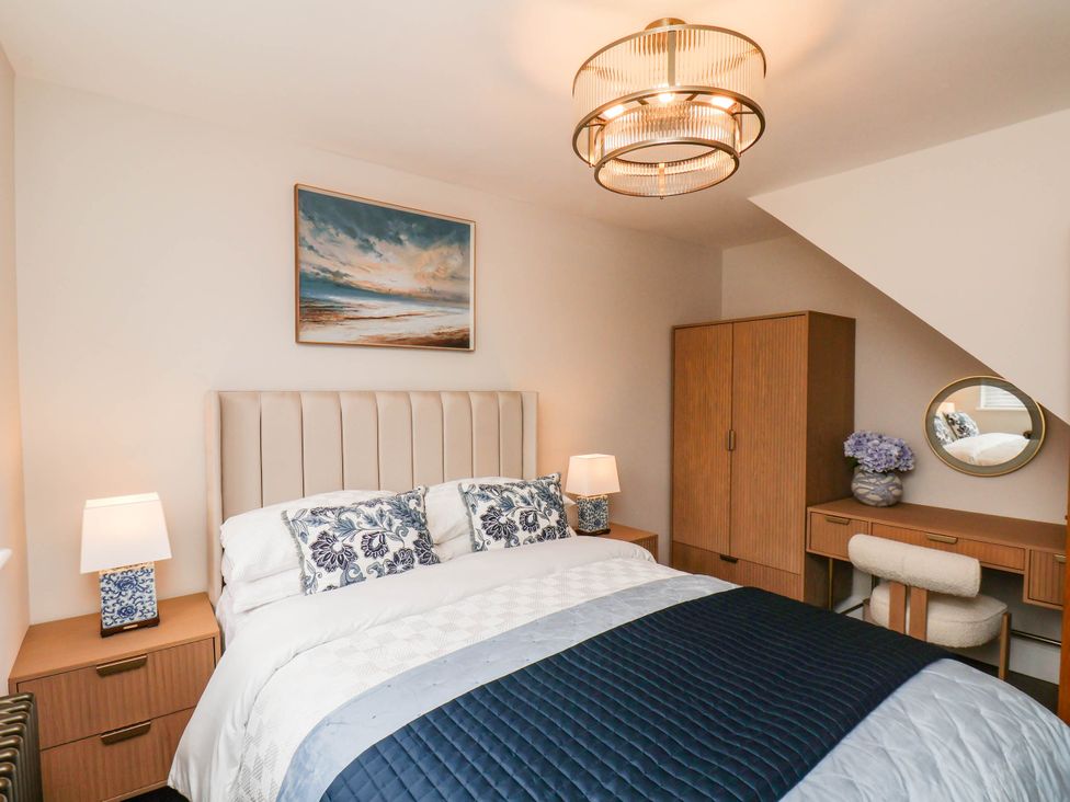 A bedroom with a bed and a dressing table at 14 Brunswick Street Whitby