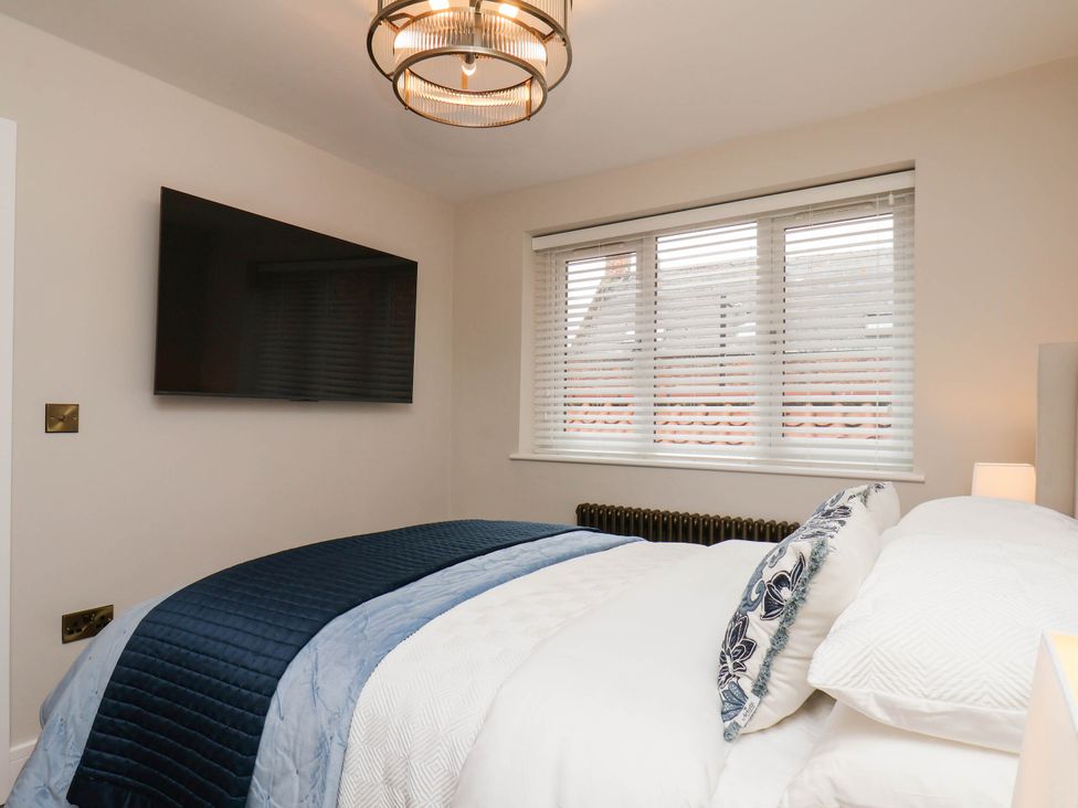 A bedroom with a bed and television at 14 Brunswick Street, Whitby