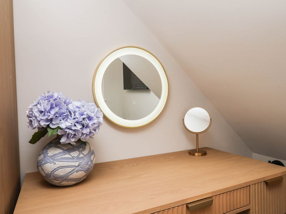 A dressing area with a mirror and flowers at 14 Brunswick Street Whitby