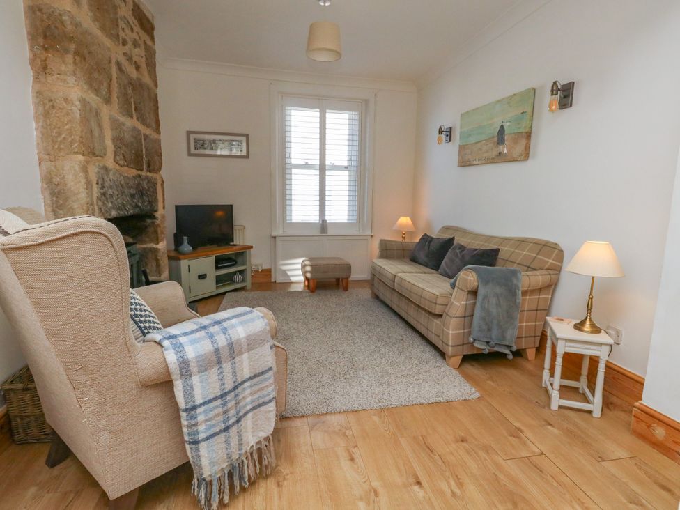 A living room with a sofa and armchair at 57 High Street in Portland