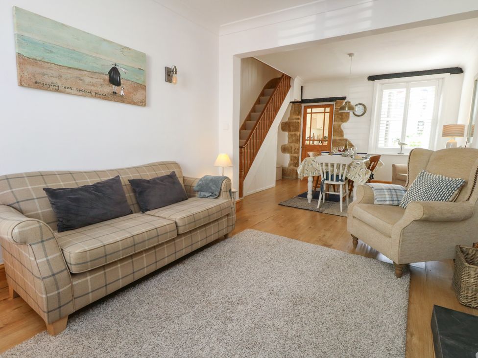 A living room with a sofa and dining area at 57 High Street Portland