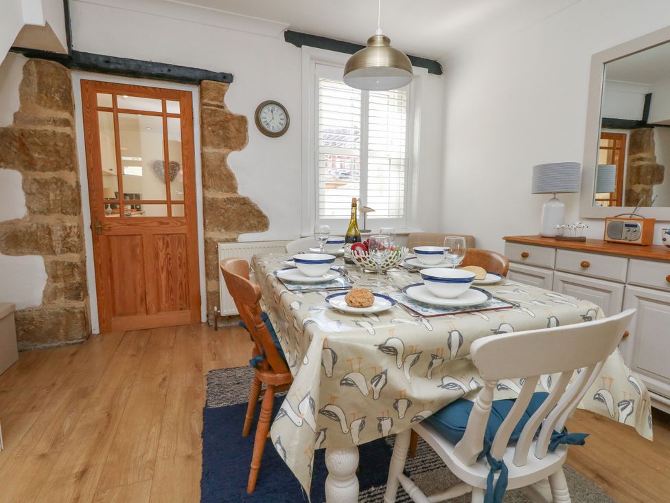A dining room with a table set for meals at 57 High Street in Portland