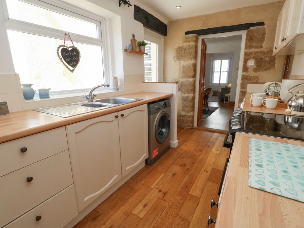 A kitchen with a sink and washing machine at 57 High Street Portland