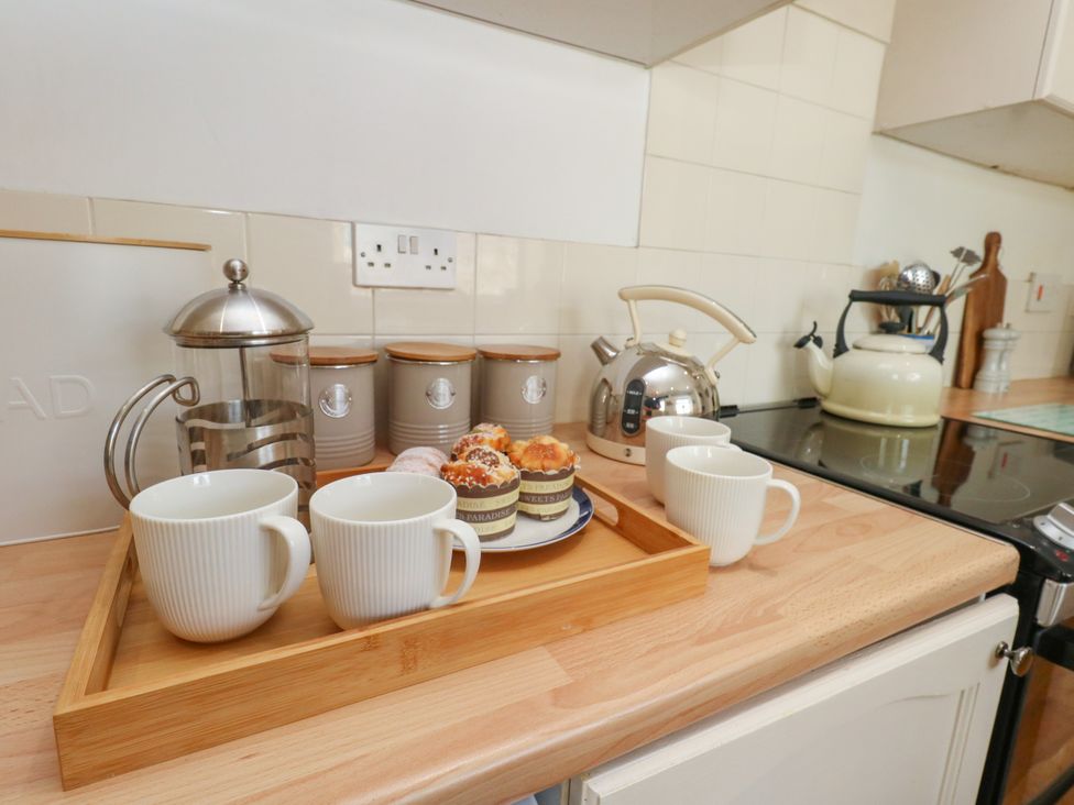 A kitchen with mugs and a coffee maker at 57 High Street in Portland