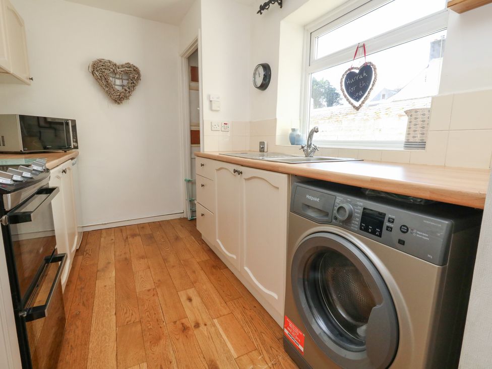 A kitchen with a washing machine and microwave at 57 High Street