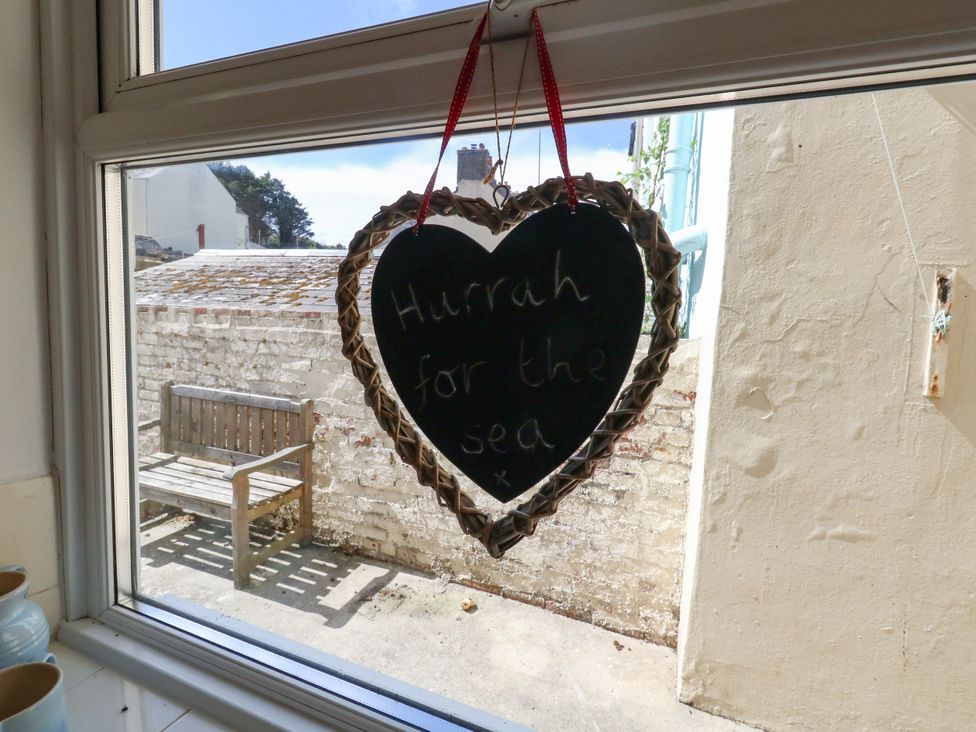 A window with a heart-shaped sign saying 'Hurrah for the sea' at 57 High Street Portland