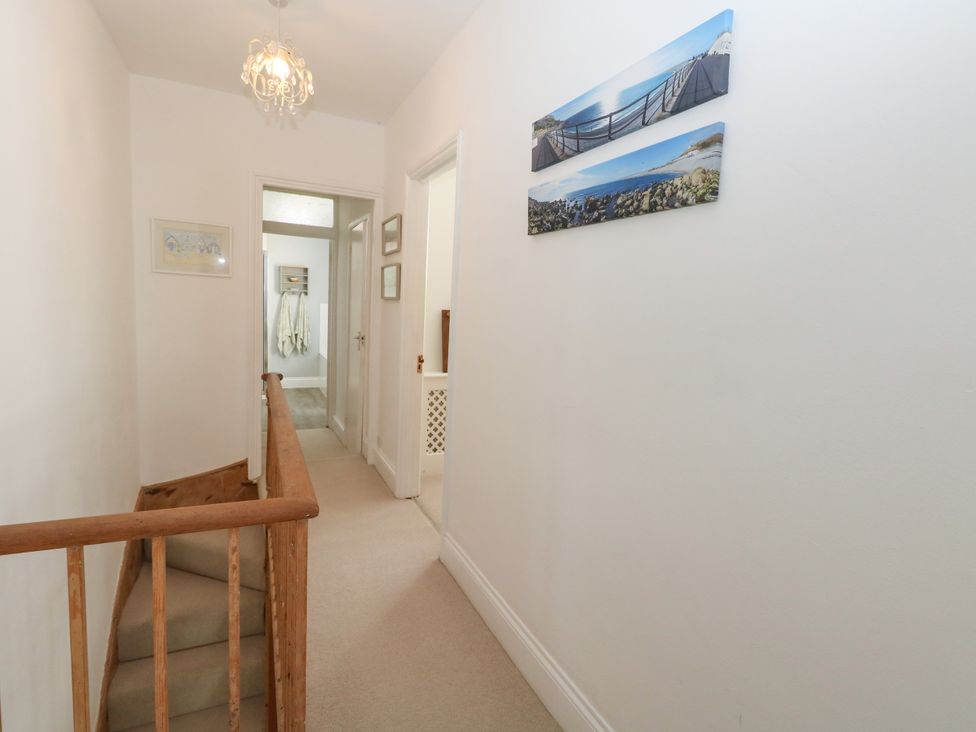 A hallway with a staircase and pictures on the wall at 57 High Street in Portland