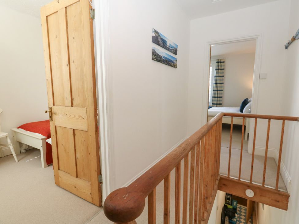 A hallway with a door and a bed in the room at 57 High Street Portland