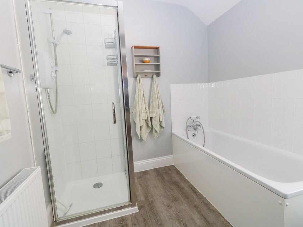 A bathroom featuring a shower and a bathtub at 57 High Street in Portland