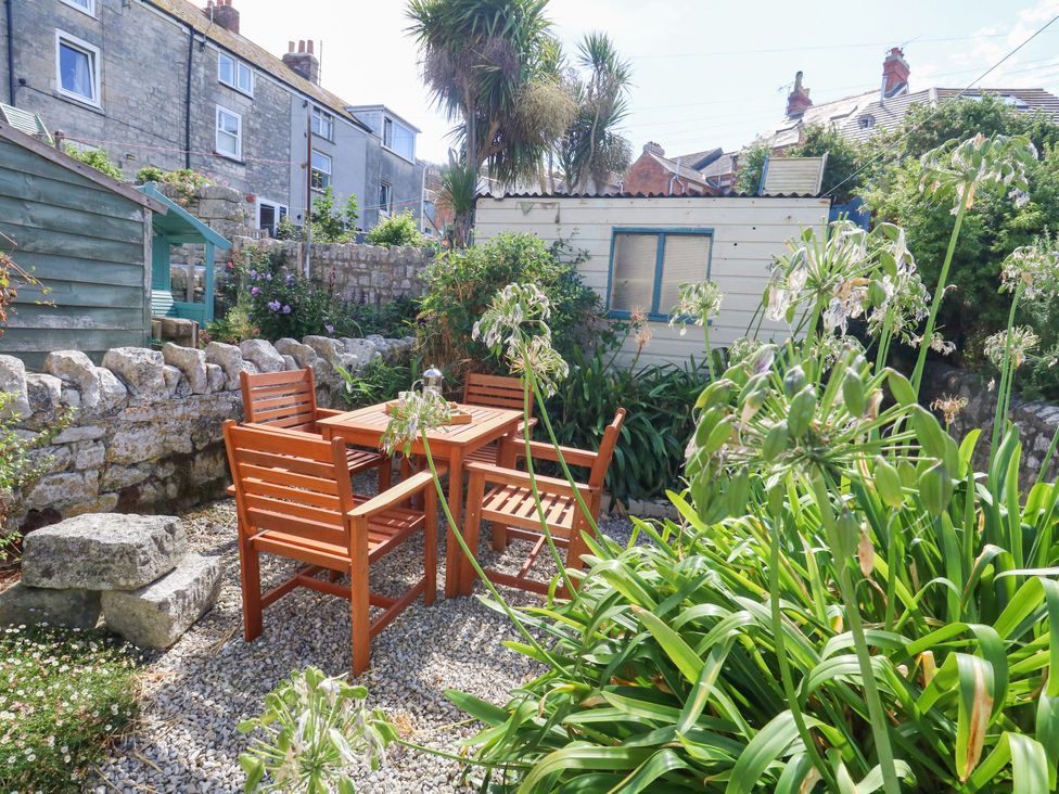 A garden with a table and chairs at 57 High Street, Portland