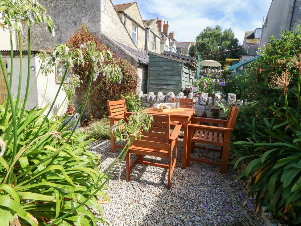 A garden with a wooden table and chairs at 57 High Street Portland