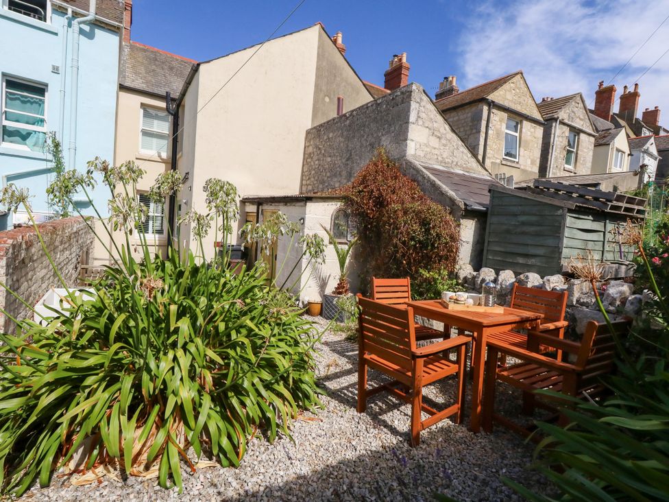 A garden with a table and chairs surrounded by plants at 57 High Street Portland
