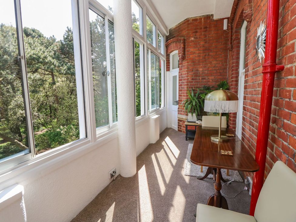 A conservatory with a table and lamp at The Pines in Bournemouth