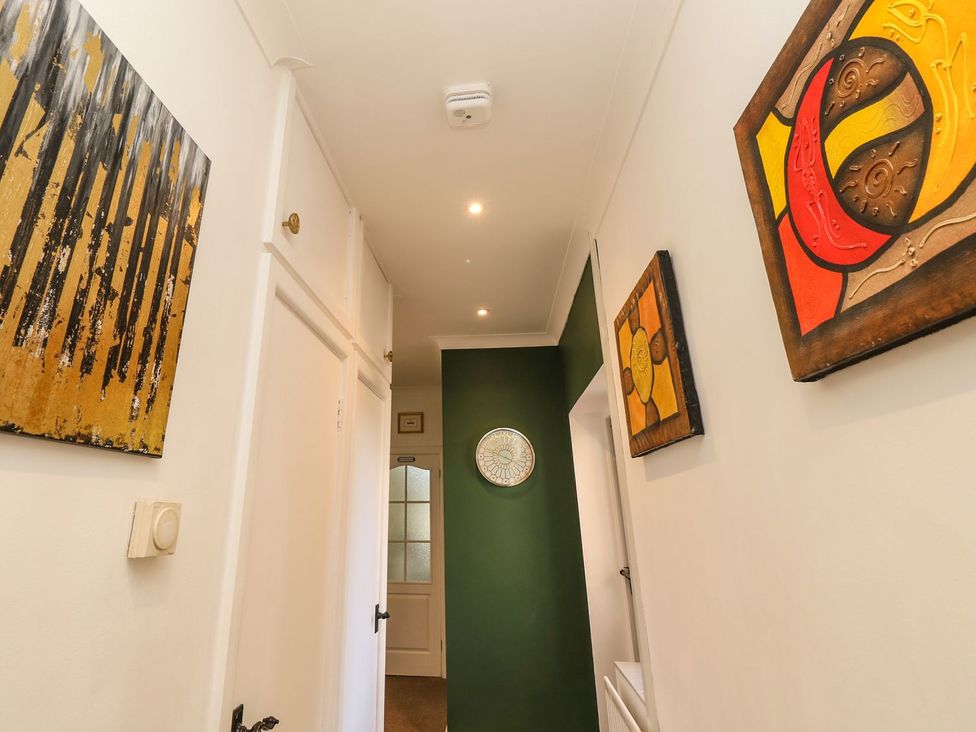 A hallway with wall art and a clock at The Pines in Bournemouth