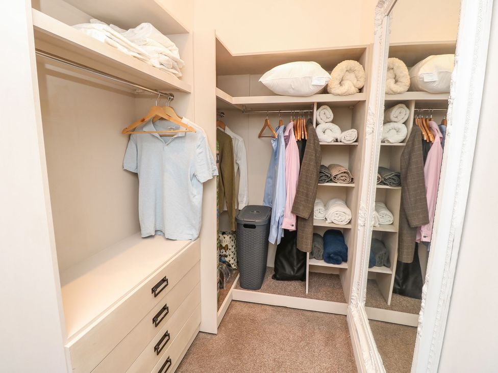 A closet with clothes and towels at The Pines in Bournemouth