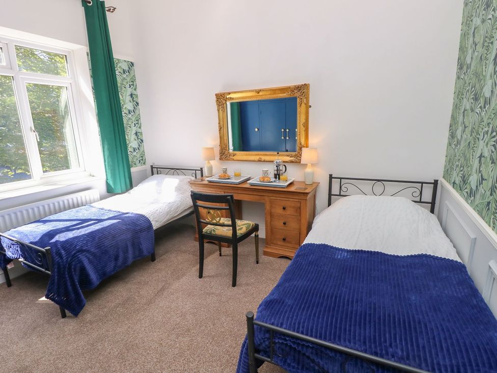 A bedroom with two beds and a table at The Pines in Bournemouth