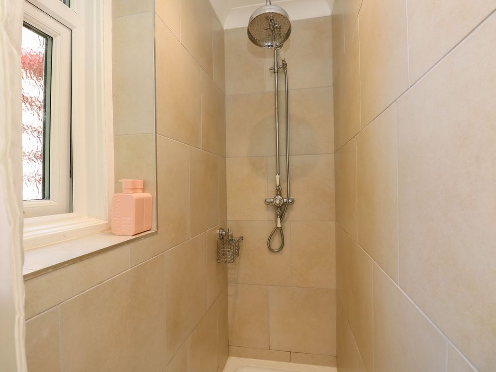 A shower with tiles and a window at The Pines in Bournemouth