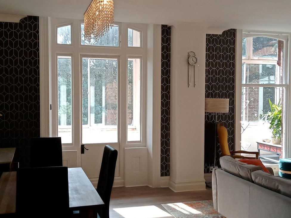 A living room with windows and a sofa at The Pines in Bournemouth